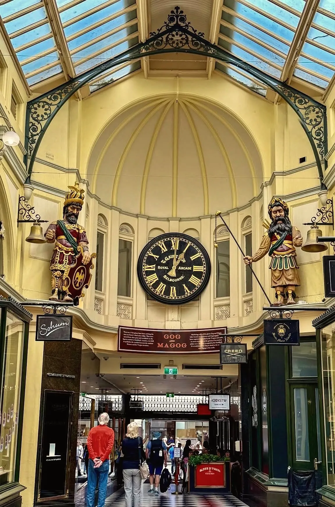 The giant painted figures of Gog and Magog standing either side of a large clock at the end of the Royal Arcade